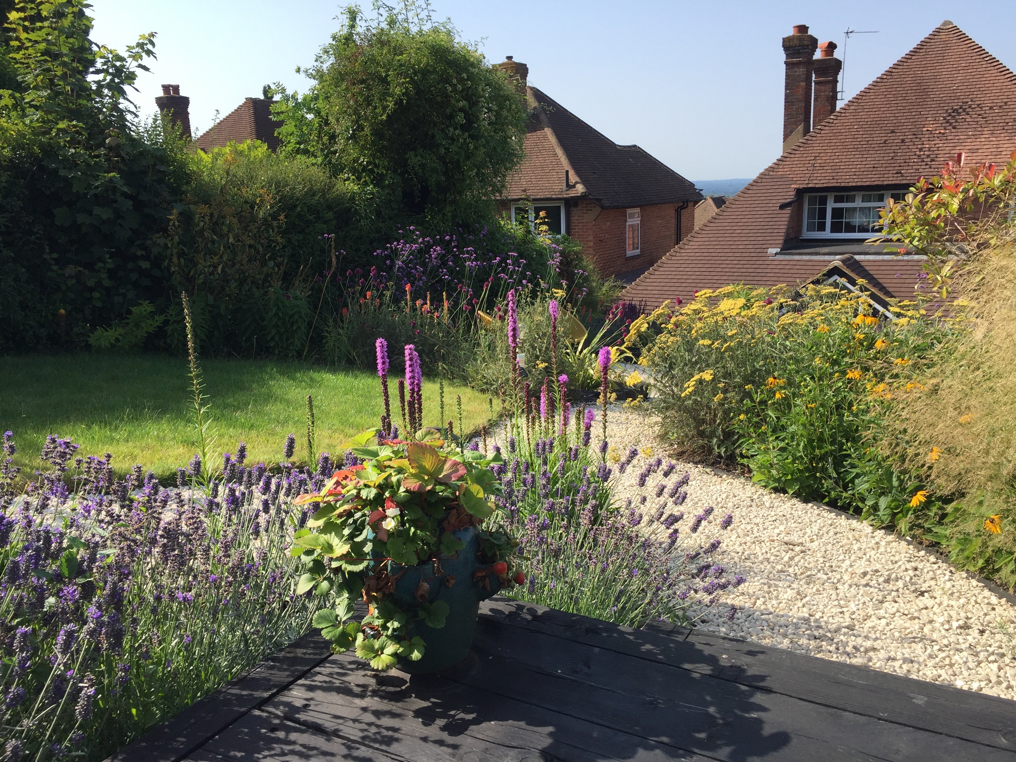 Photo of two women and a man talking in the corner of a room with modern furniture.